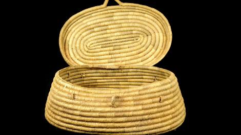 An oval basket, tapering out the base, with a lid but no handle.